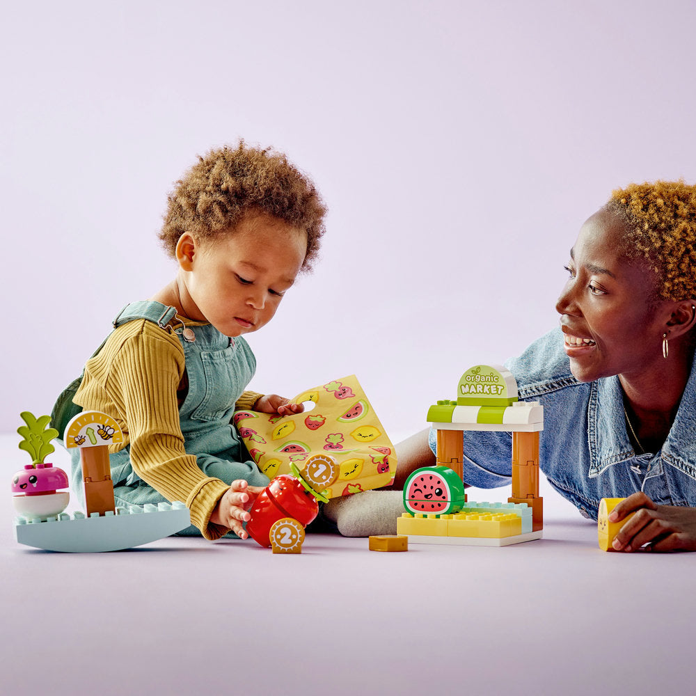 Set LEGO DUPLO Mi Primer Mercado Orgánico (10983) con frutas y verduras de juguete, balanza, monedas y bolsa de tela. Un colorido mercado para bebés que fomenta el juego educativo, la motricidad fina y el aprendizaje sobre alimentos saludables.
