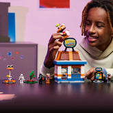 Set LEGO Fortnite Restaurante Hamburrrguesa (77076) para niños y niñas a partir de 10 años, inspirado en el icónico restaurante del videojuego. Incluye edificio modular con caja registradora, máquina de refrescos y terraza, además de 4 minifiguras: Bombardera playera, Caudillo cárnico, Parco y un esqueleto. Contiene accesorios y un código QR para desbloquear el traje de Caudillo cárnico en LEGO Fortnite.